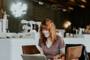 A pretty lady sitting and operating her laptop as she does reddit online dating