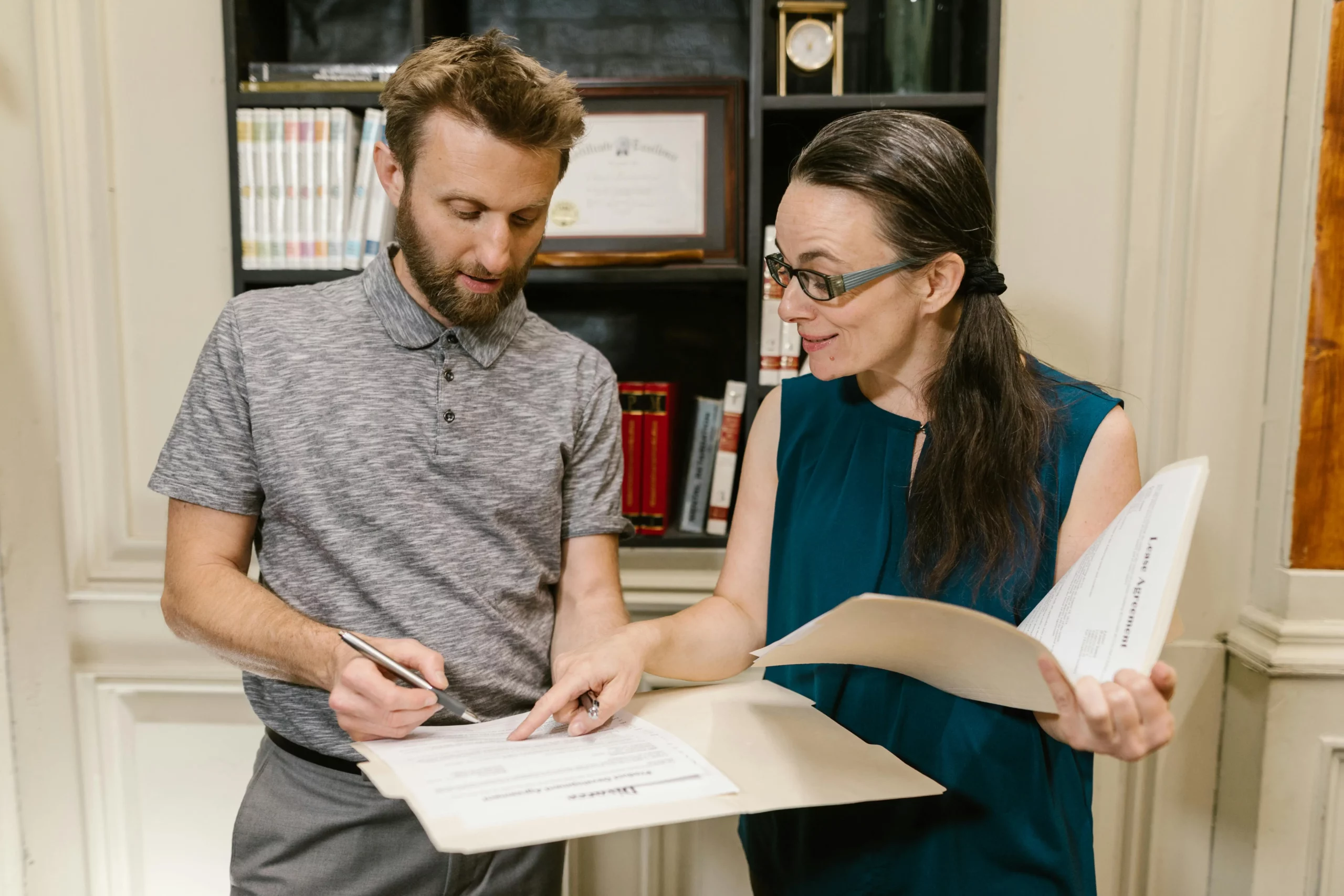 Male and female Maryland Divorce Laws attorney in the office reviewing some sets of documents together