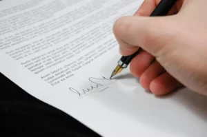 A hand signing a marriage document