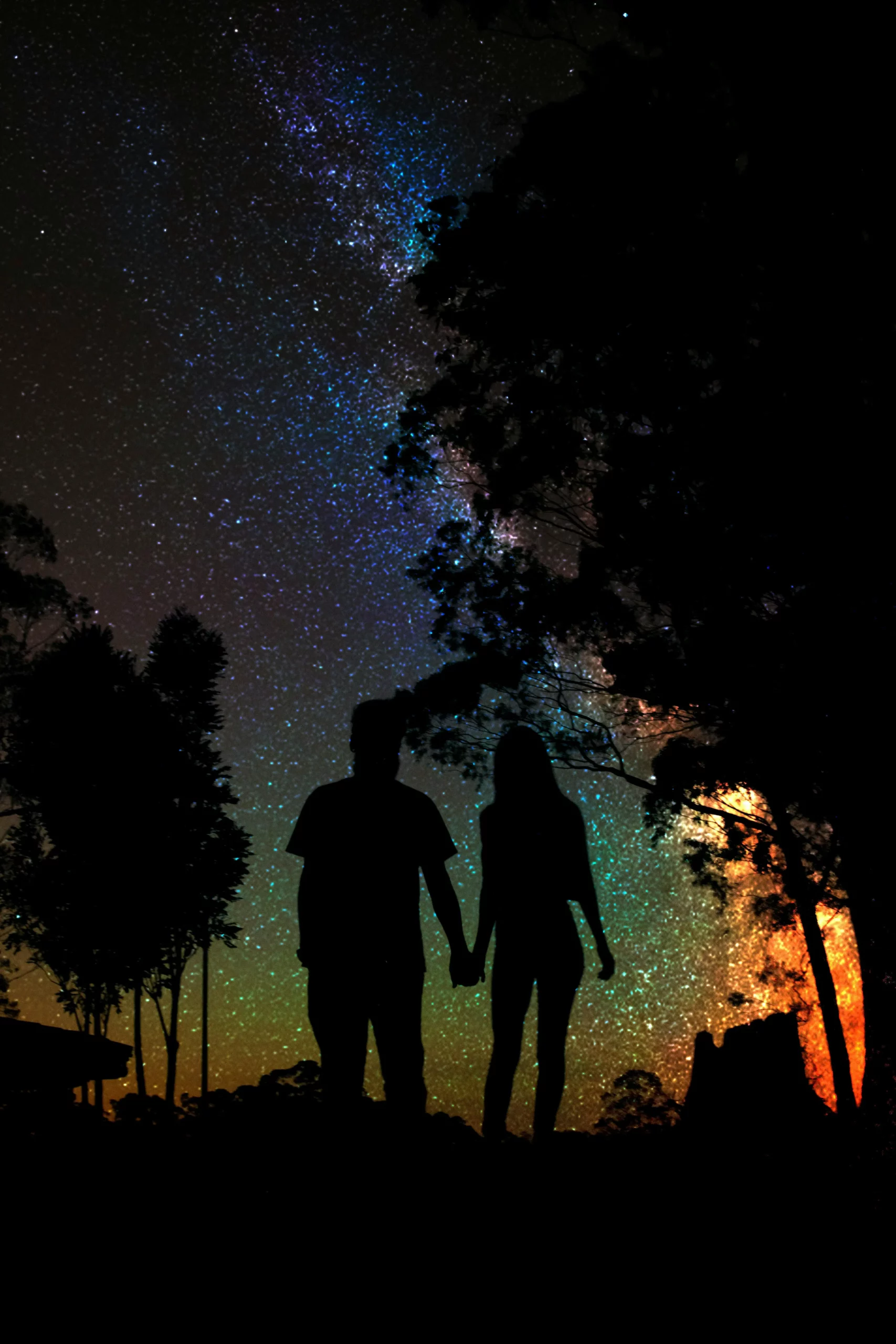 Couples holding hands as they practice astrology on conflict resolution in the night under bright shinning stars